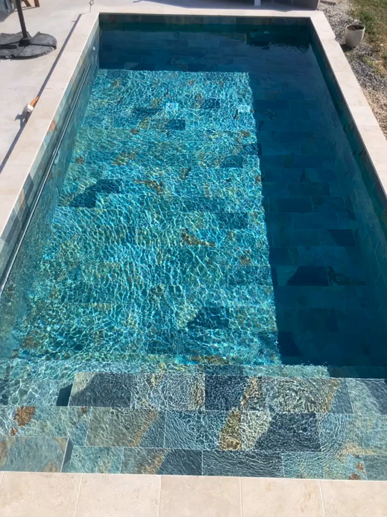 Piscine extérieure avec eau turquoise scintillante.