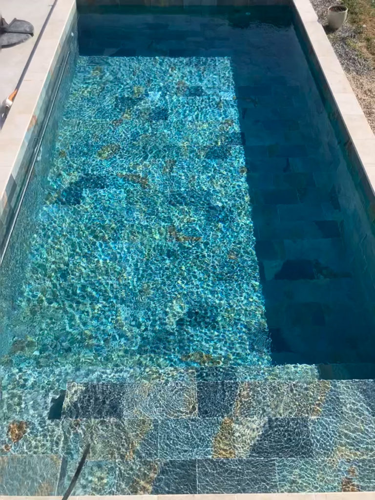 Piscine avec eau turquoise ensoleillée.