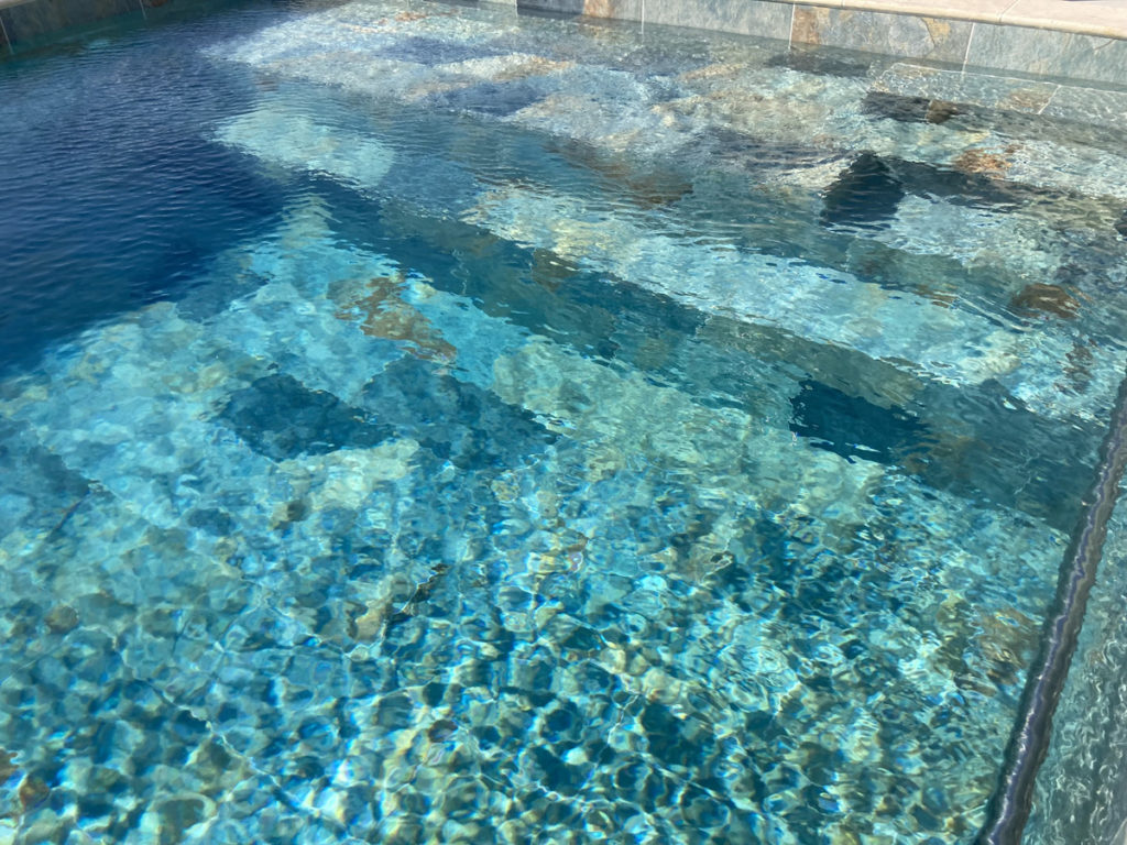 Eau cristalline d'une piscine turquoise.