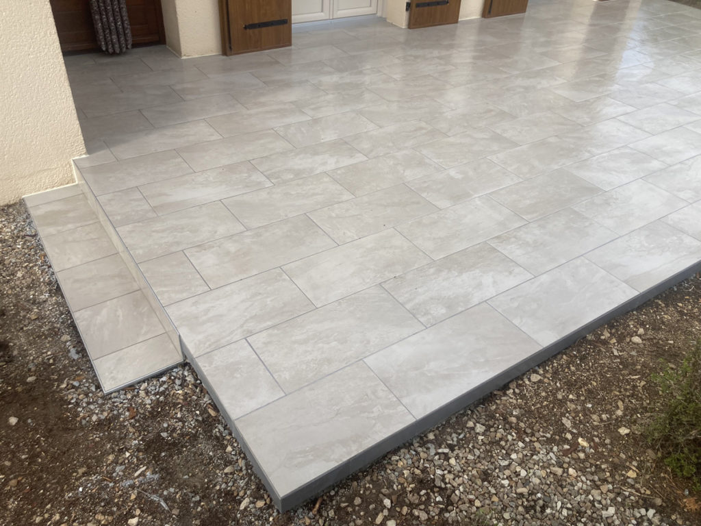 Terrasse en carrelage gris clair avec petit escalier