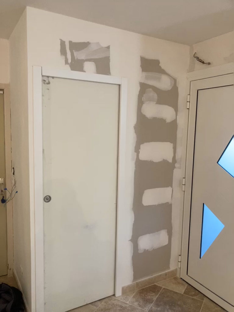 Mur partiellement rénové près de deux portes.