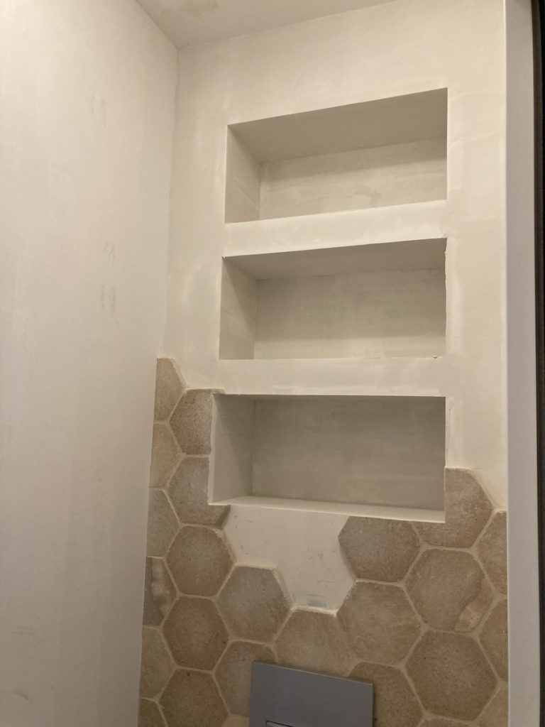 Étagères murales avec carrelage hexagonal beige moderne.