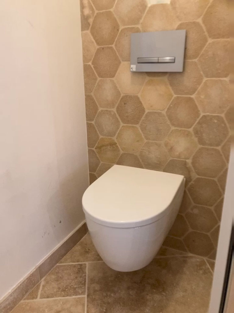Toilettes modernes avec carrelage hexagonal beige.