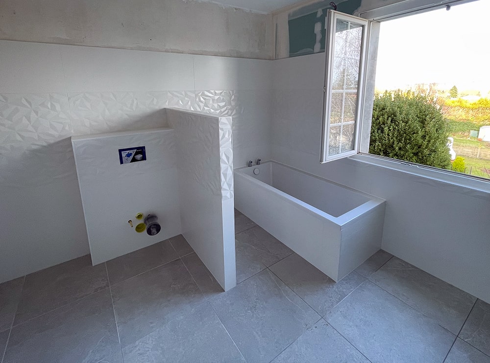 Salle de bain moderne avec baignoire et fenêtre ouverte.