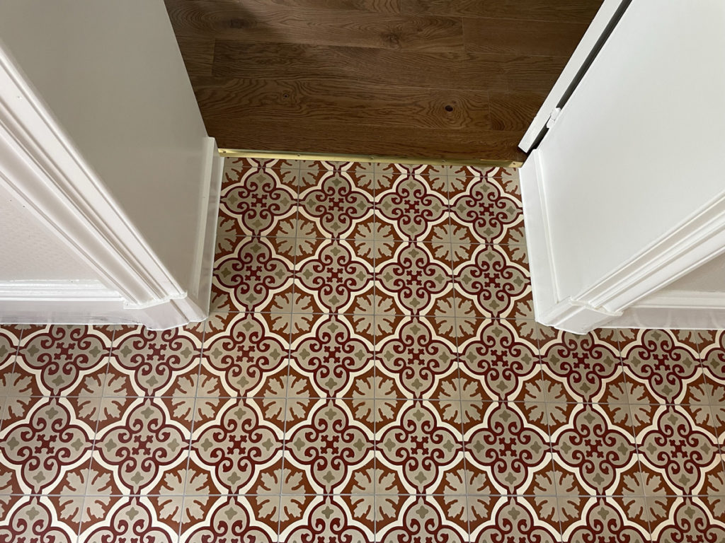 Carrelage rouge et blanc avec motif géométrique.