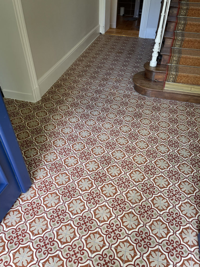 Carrelage décoratif rouge et blanc dans un couloir.