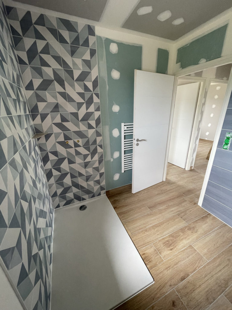 Douche moderne avec carrelage géométrique et parquet bois