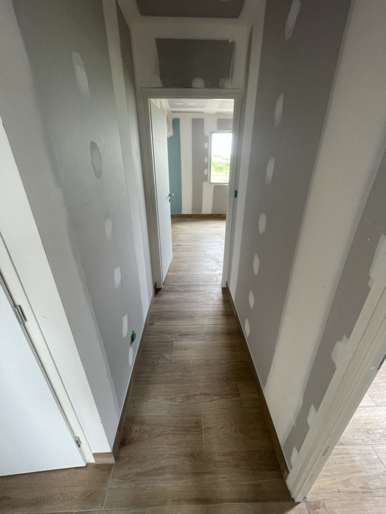 Couloir de maison en rénovation avec parquet bois.