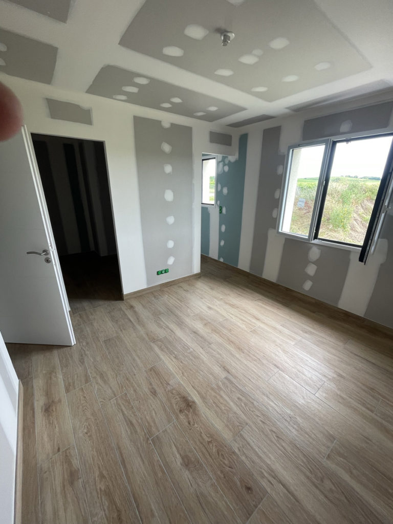 Chambre rénovée avec plancher en bois clair.