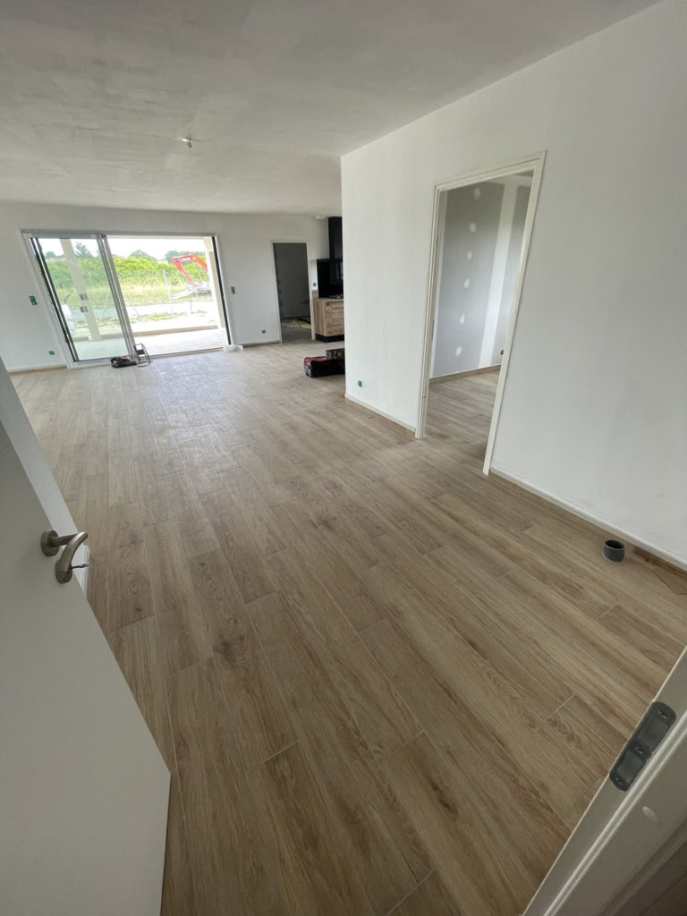 Intérieur moderne avec parquet et grandes fenêtres.