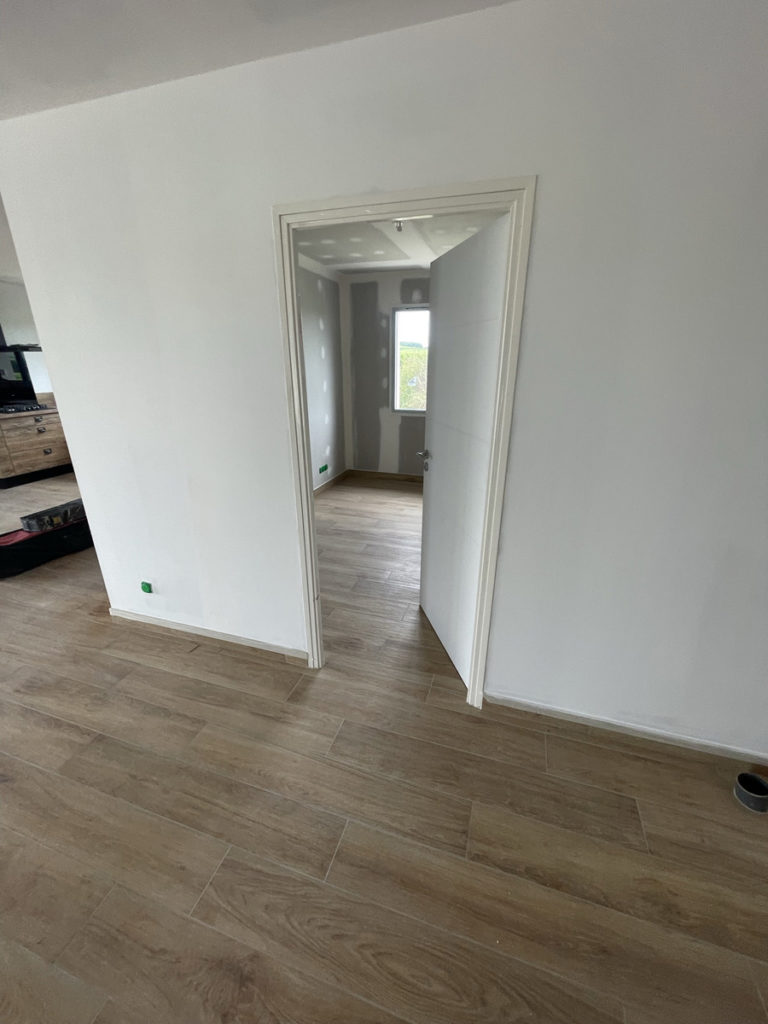 Nouvelle chambre avec parquet en bois clair.