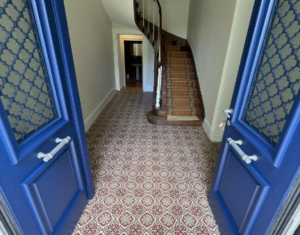 Hall d'entrée avec escalier et portes bleues.