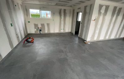 Pièce en rénovation avec carrelage gris.
