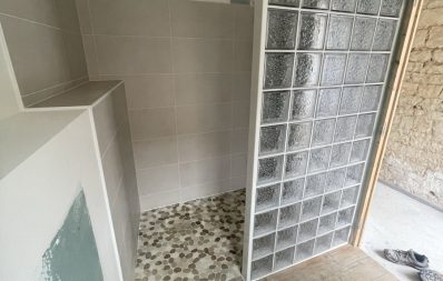 Douche en construction avec paroi en verre.