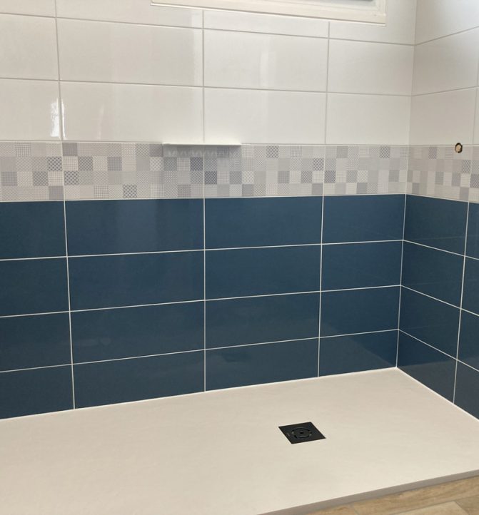 Douche moderne avec carrelage bleu et blanc.